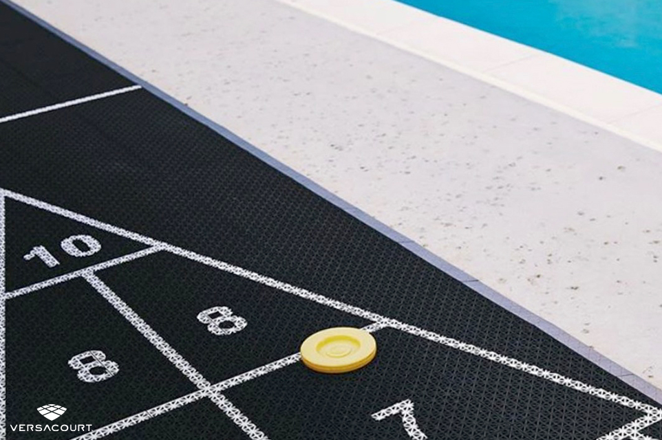 Shuffleboard court next to backyard pool