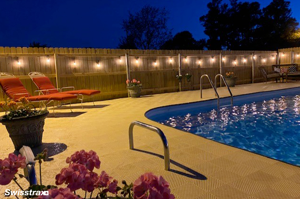 Swisstrax modular tiles covering the concrete around a backyard pool