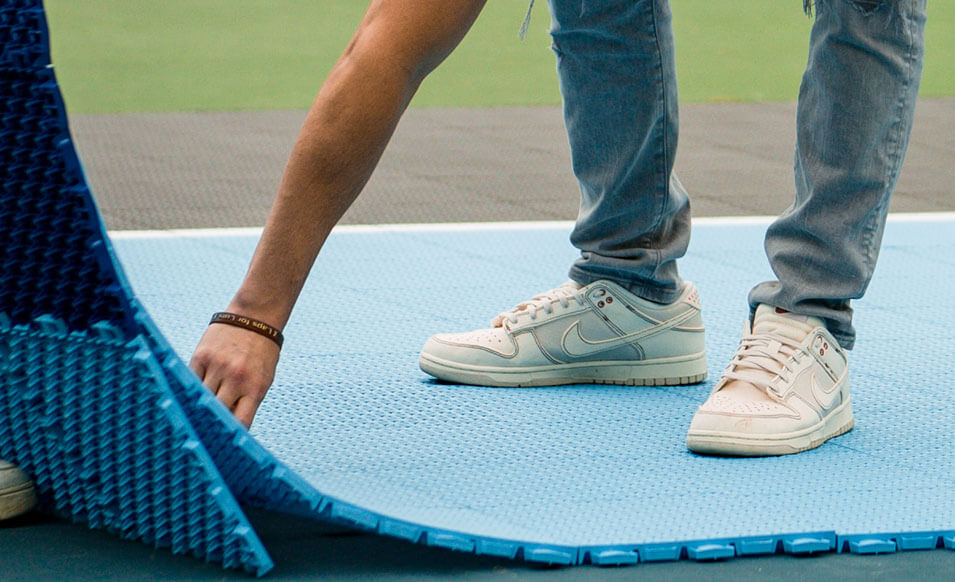 a closeup showing a person installing pickeball court tile