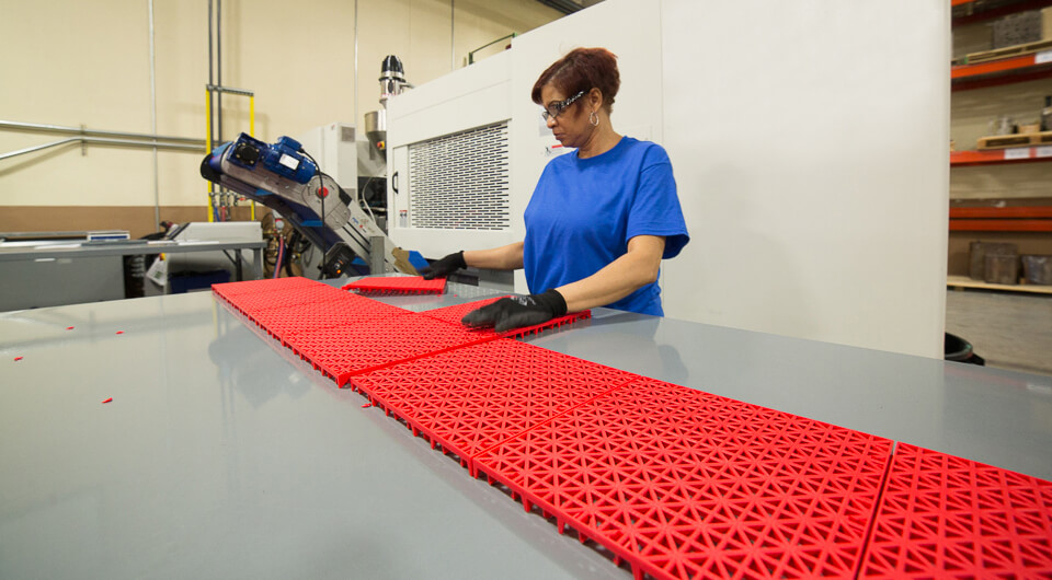 a lady constructing red pickleball court tile