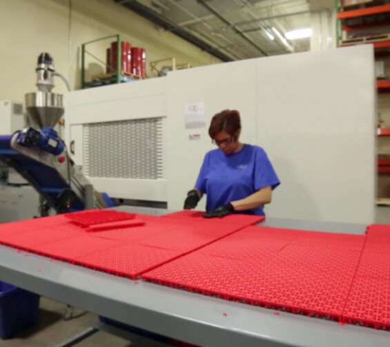 a woman inspects tiles manually as part of quality control process
