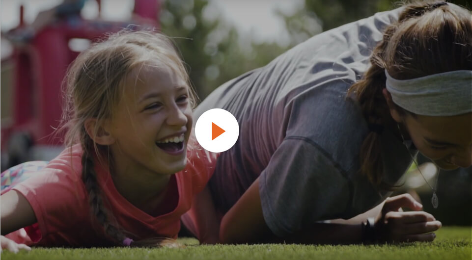 stillframe from video - children laughing while playing on turf