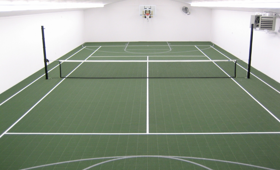 Indoor court with basketball hoops and tennis net